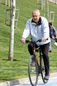 Elderly man riding a bicycle outdoors, promoting healthy lifestyle and fitness.