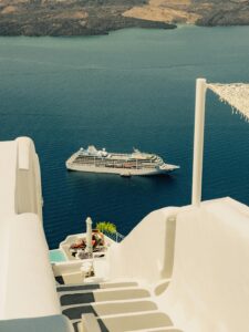 Serene view of a cruise ship from the iconic white buildings of Santorini.