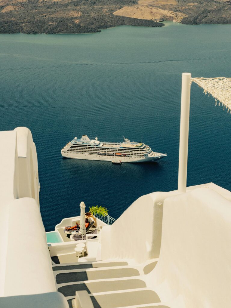 Serene view of a cruise ship from the iconic white buildings of Santorini.