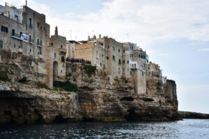 Picturesque stone houses perched on cliffs above the Adriatic Sea in Polignano a Mare, Italy.