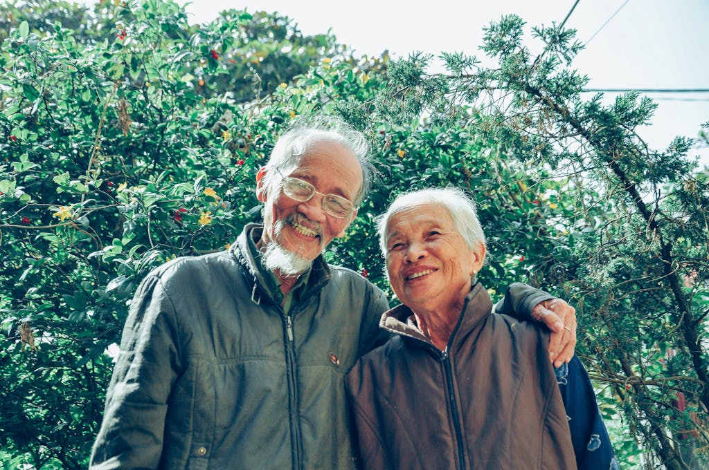Senior couple enjoying a joyful moment together in a lush garden setting, exuding love and happiness.